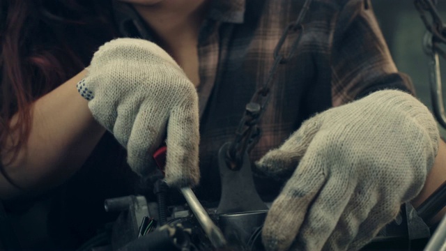车间车库里的女人。修复引擎。近距离观察双手视频下载