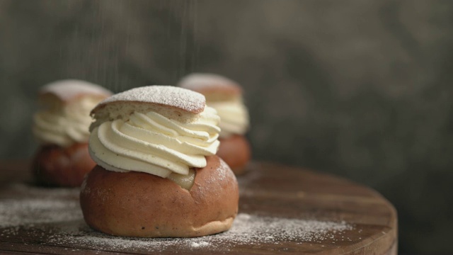 在瑞典传统的Semlor甜点上洒糖视频素材