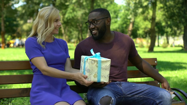 非裔美国人在公园看书，得到惊喜的女性朋友在场视频素材