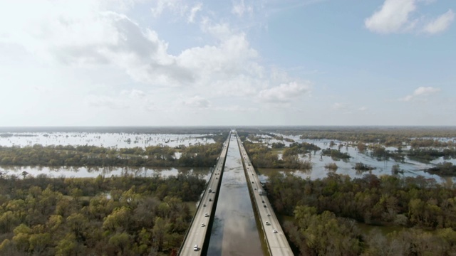 无人机拍摄的布鲁桥(10号州际公路)和Atchafalaya河流域沼泽包围柏树林在路易斯安那南部在一个阳光明媚但部分多云的天空视频下载