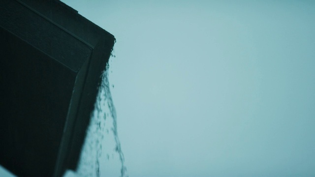 机架聚焦拍摄雨滴落在屋顶与雨水倾泻下来视频素材