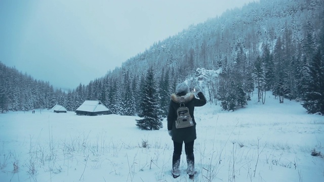 用智能手机拍摄冬季森林和山脉的全景。视频素材