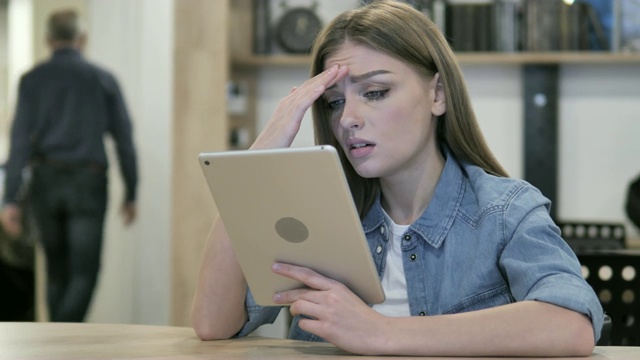 紧张的女孩在使用平板电脑时对经济损失的反应视频素材