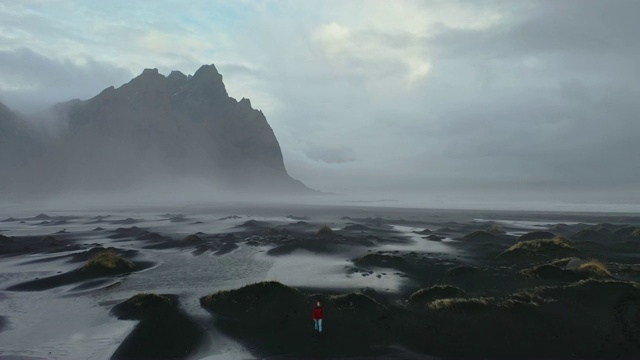 冰岛黑沙滩上女人的鸟瞰图视频素材