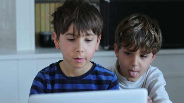 孩子们在电脑前上网看网络媒体内容。随意率真的真实场景视频素材