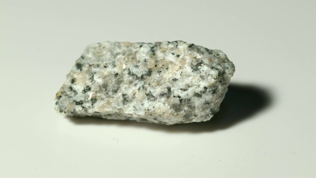 花岗岩片麻岩矿物样品在白色背景旋转视频下载