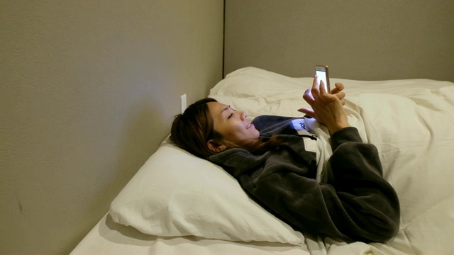 4K拍摄:一名亚洲女性住在日式传统酒店。她在深夜睡觉前玩电子游戏视频素材