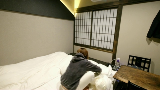 4K后续镜头:女性游客住在日式传统酒店。一个昏昏欲睡的女人走进酒店房间。视频素材