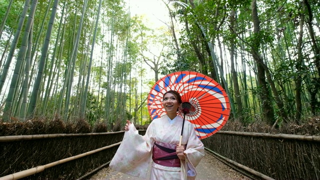 4K吊车拍摄:日本京都岚山和佐野竹林，一名身穿传统和服的亚洲女性乘坐日本人力车——欢迎你来到日本视频购买