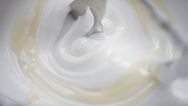 在实验室里，搅拌机搅拌白色奶油，同时加入米色液体视频下载