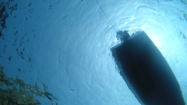 水下拍摄的船底漂浮与引擎关闭。视频素材
