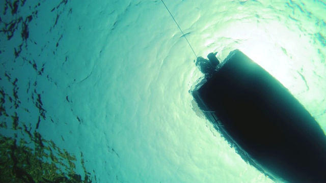 水下拍摄的船底漂浮与引擎关闭。视频素材