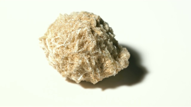 沙漠玫瑰岩矿物石样品以白色为背景旋转视频下载