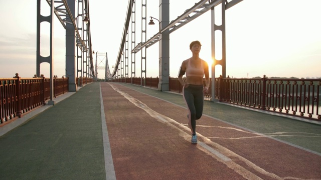 漂亮的健身女士在人行天桥上跑步视频素材