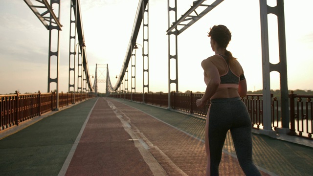 桥上健康的资深女跑步者的后视图视频素材