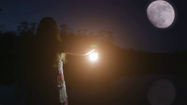 女孩提着灯笼，望着月亮。视频素材