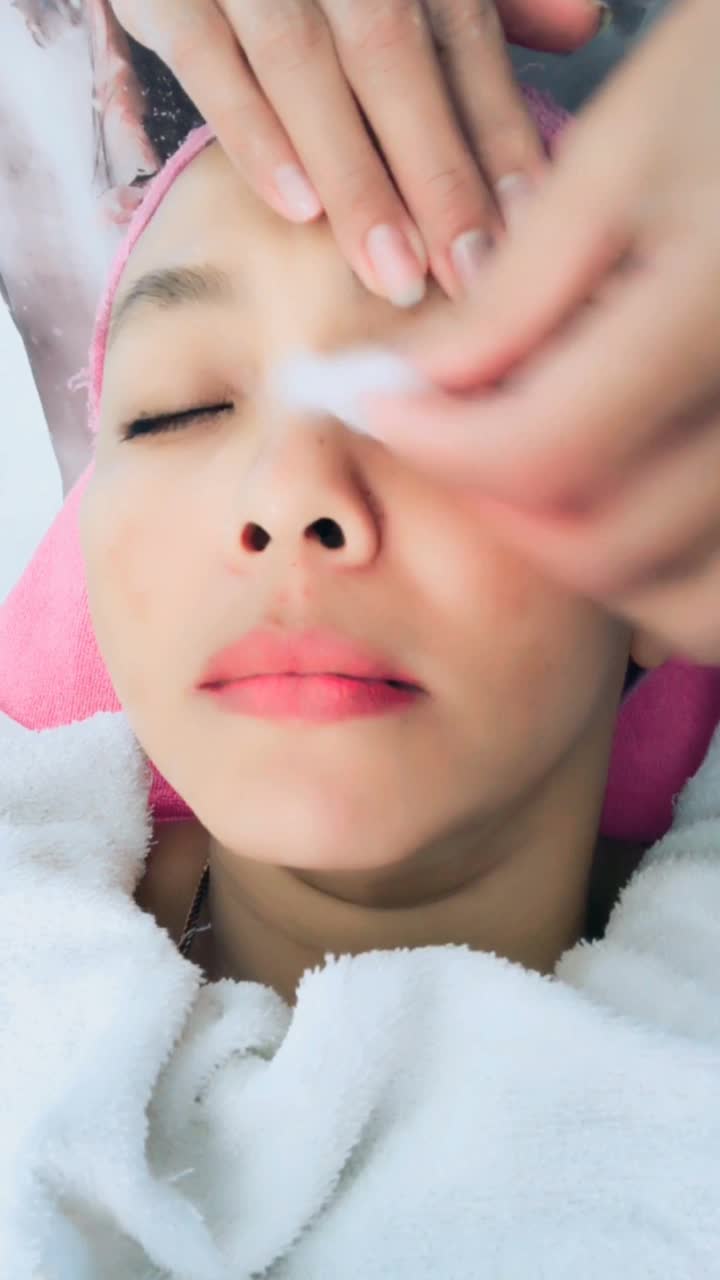 皮肤科医生应用脸部保湿面膜和按摩在女人的脸，垂直视频智能手机视频下载