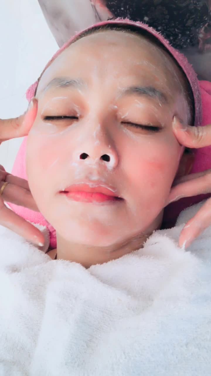 皮肤科医生应用脸部保湿面膜和按摩在女人的脸，垂直视频智能手机视频下载