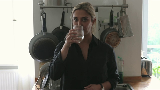 自信的中年女性设计师在家里喝水的肖像视频下载