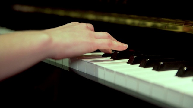 在钢琴上弹奏琴键的手指的特写视频素材