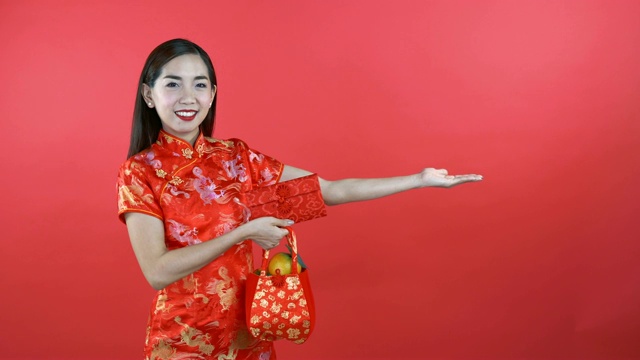 穿着中式服装的女人拿着钱袋和橙色的袋子视频下载