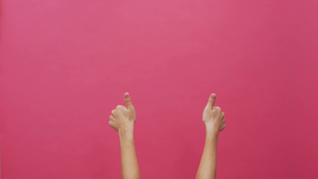 女人在孤立的粉色背景上竖起大拇指4k视频下载