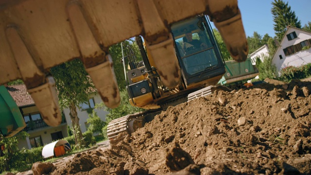 SLO MO挖掘机铲斗在阳光明媚的施工现场挖土视频下载