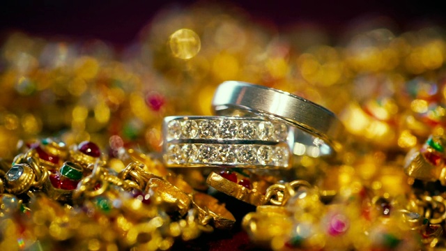 微距拍摄的结婚戒指与金色的背景。视频素材