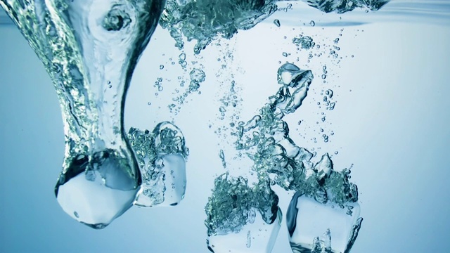 慢镜头拉近了4块冰块落入水中，在水下产生各种大小的气泡视频下载