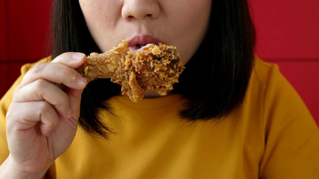 女人吃垃圾食品炸鸡，慢镜头视频下载