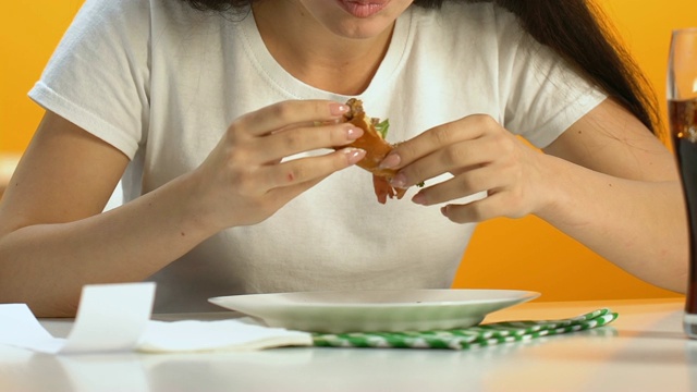 饥饿的女人吃汉堡有食欲，快餐成瘾增加超重视频素材