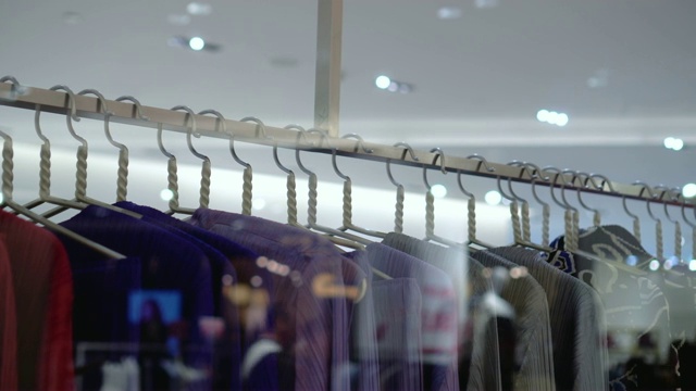 4k视频拍摄百货公司、购物中心、服装概念店的挂衣架和衣架扶手的场景视频素材