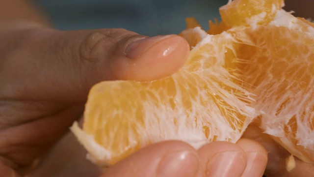 年轻女子剥橘子皮视频素材