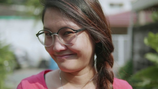 年轻亚洲女性的肖像看着相机，微笑，快乐。视频素材