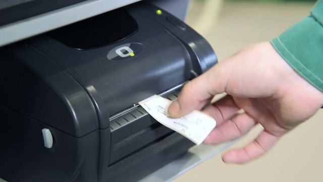 人的手从打印机取出打印好的标签。在磁带上打印的打印机视频下载