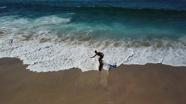 一个面目全非的人跑向海浪准备冲浪视频下载