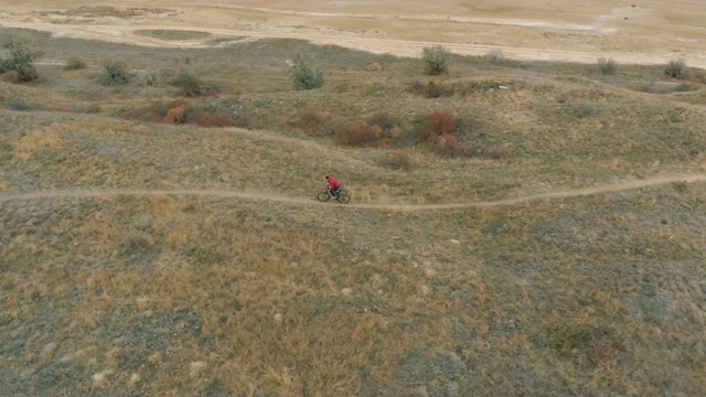 在秋日的湖边，人们骑着山地车。从无人机拍摄视频素材