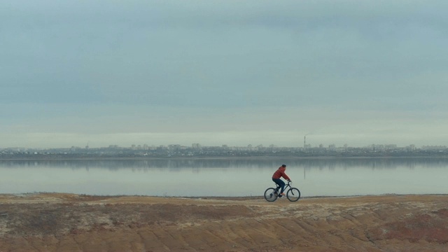 在秋日的湖边，人们骑着山地车。从无人机拍摄视频素材