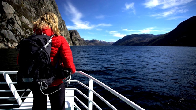 女徒步旅行者在船上观看吕瑟峡湾挪威视频素材