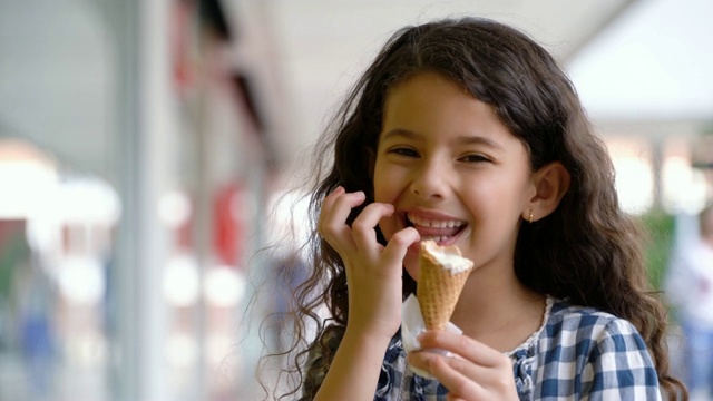 漂亮的小女孩在商场里享受美味的冰淇淋视频下载
