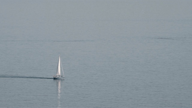 一艘孤独的游艇在平静的水面上视频下载