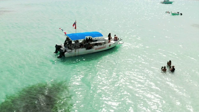 航拍:在湛蓝的海洋上漂浮的摩托艇和水中的人视频下载