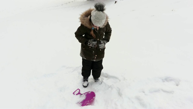 小女孩完成滑雪橇和清洁冬衣视频下载