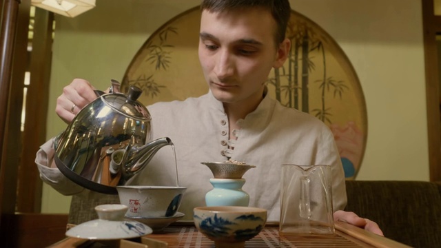 仪式上，茶师将热水从茶壶倒入盖湾冲泡茶叶视频素材