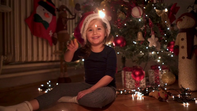 兴高采烈的孩子戴着圣诞帽与烟花玩得很开心视频下载