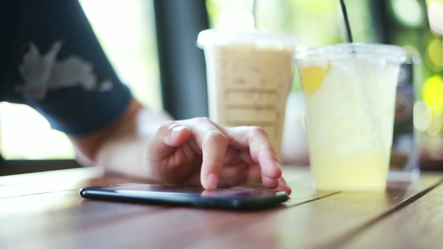 女人的手在咖啡馆使用智能手机的特写视频素材