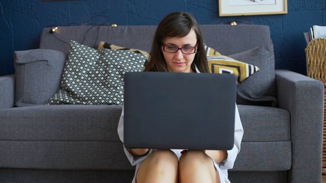 坐在地板上用笔记本电脑打字的女人视频素材