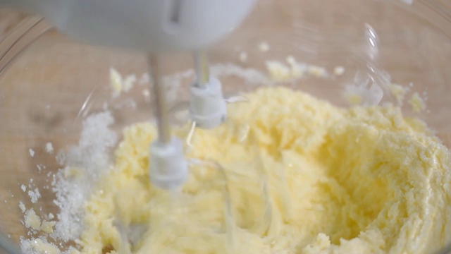 用搅拌机将黄油和砂糖放入碗中搅拌，制作面包视频素材