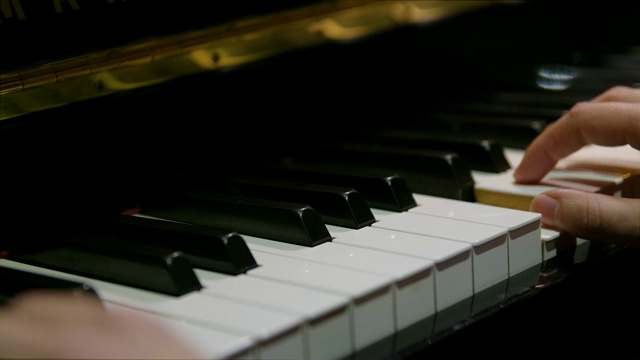 当他们在钢琴上弹奏和弦时，拉近手指视频素材
