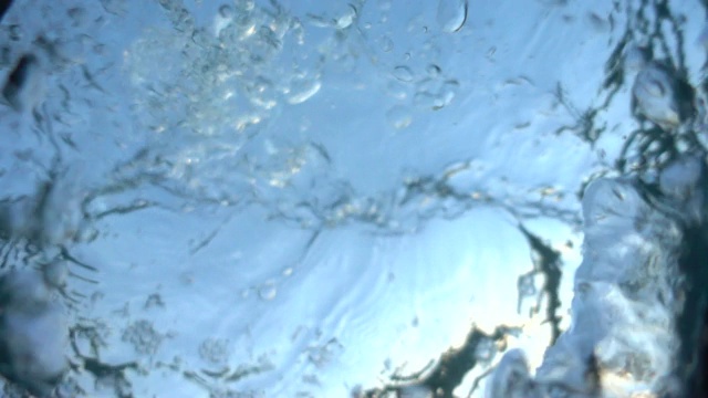 潜入水中。以慢动作落入水中。不同大小的泡沫在泡沫的绿松石水。下沉。版本2。视频素材